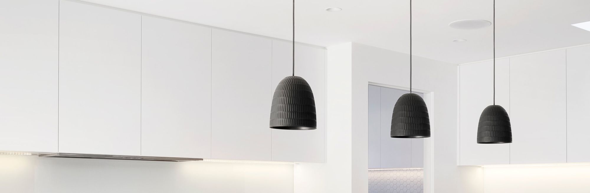 Pendants in a row in a white kitchen
